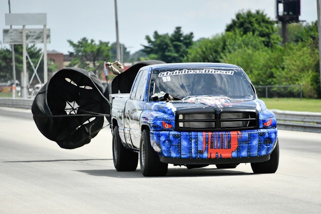 At the end of a race a car opens a parachute. Why do they do this?