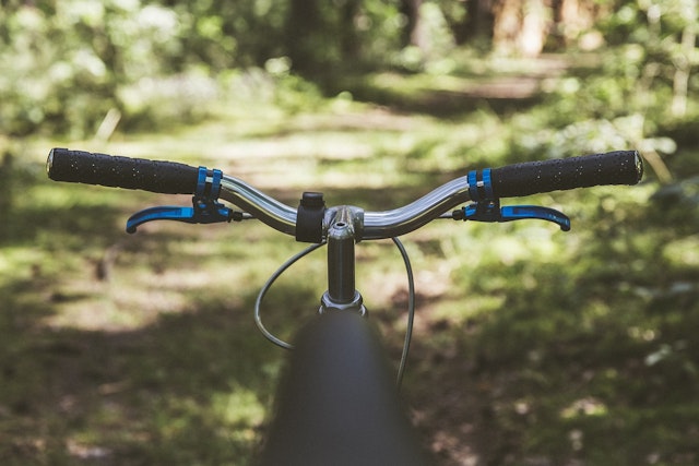 Why is it easier to steer a bicycle with wide handlebars, like those shown, than one with narrower handlebars?